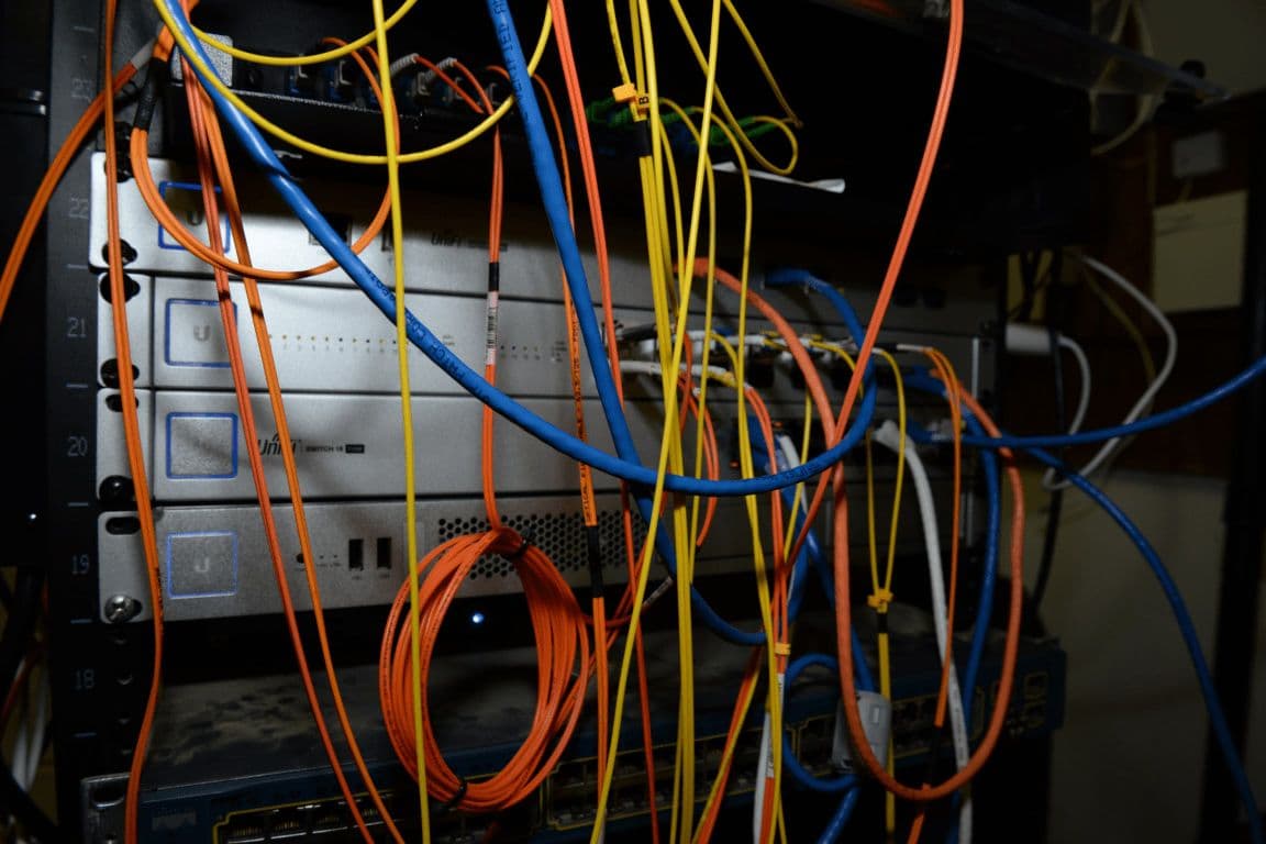 A dense bundle of coloured network cables in a patch panel.
